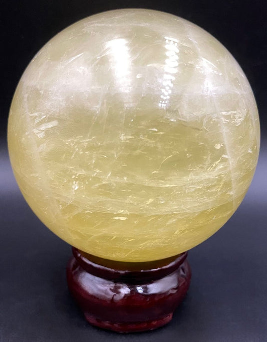 Sfera din piatra semipretioasa de citrin pe suport din lemn cu fundal negru