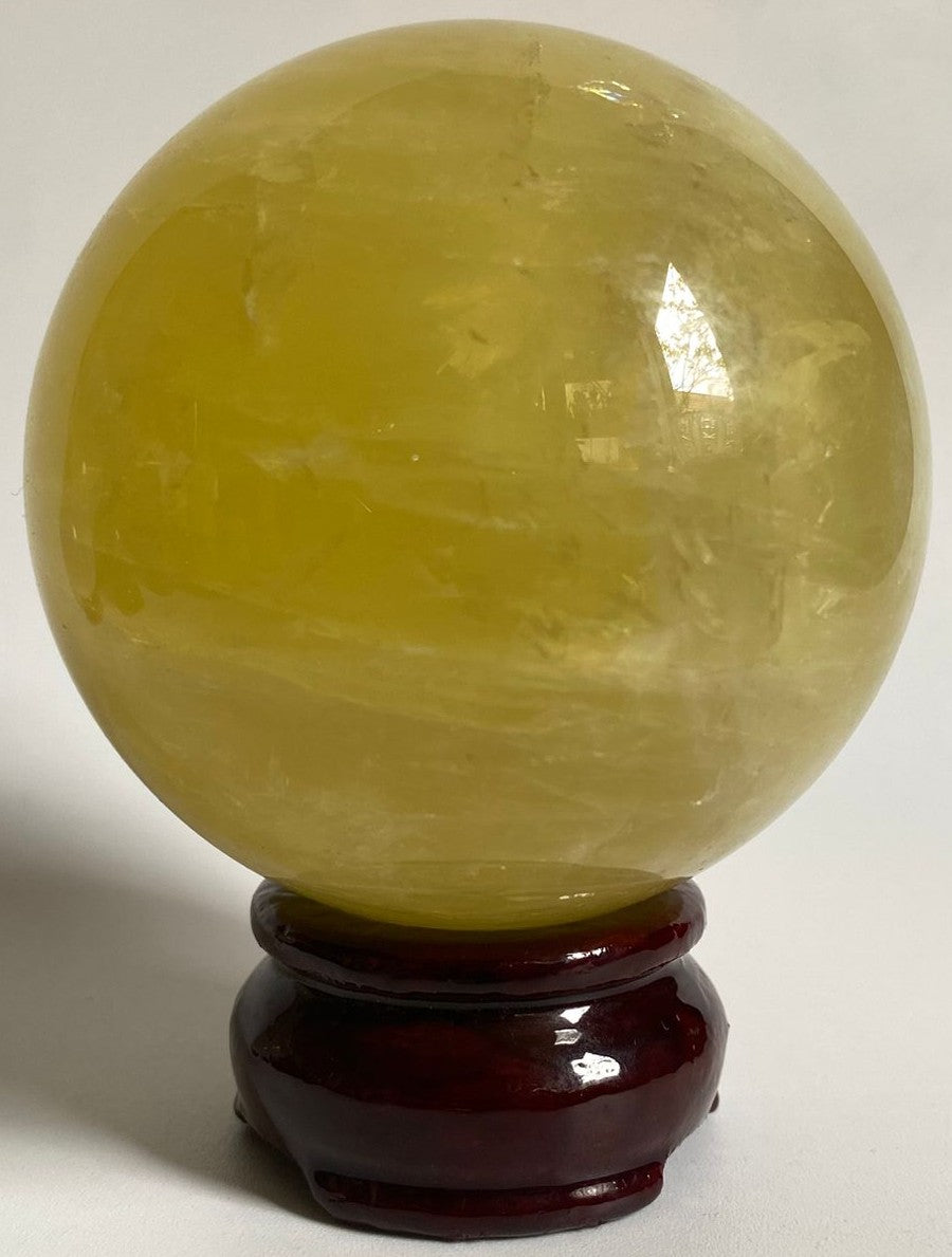 Sfera de 7.6cm din cristal de citrin pe suport din lemn cu fundal alb