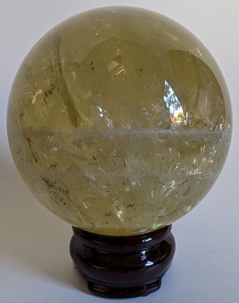 Sfera din cristal de citrin pe suport din lemn cu fundal alb