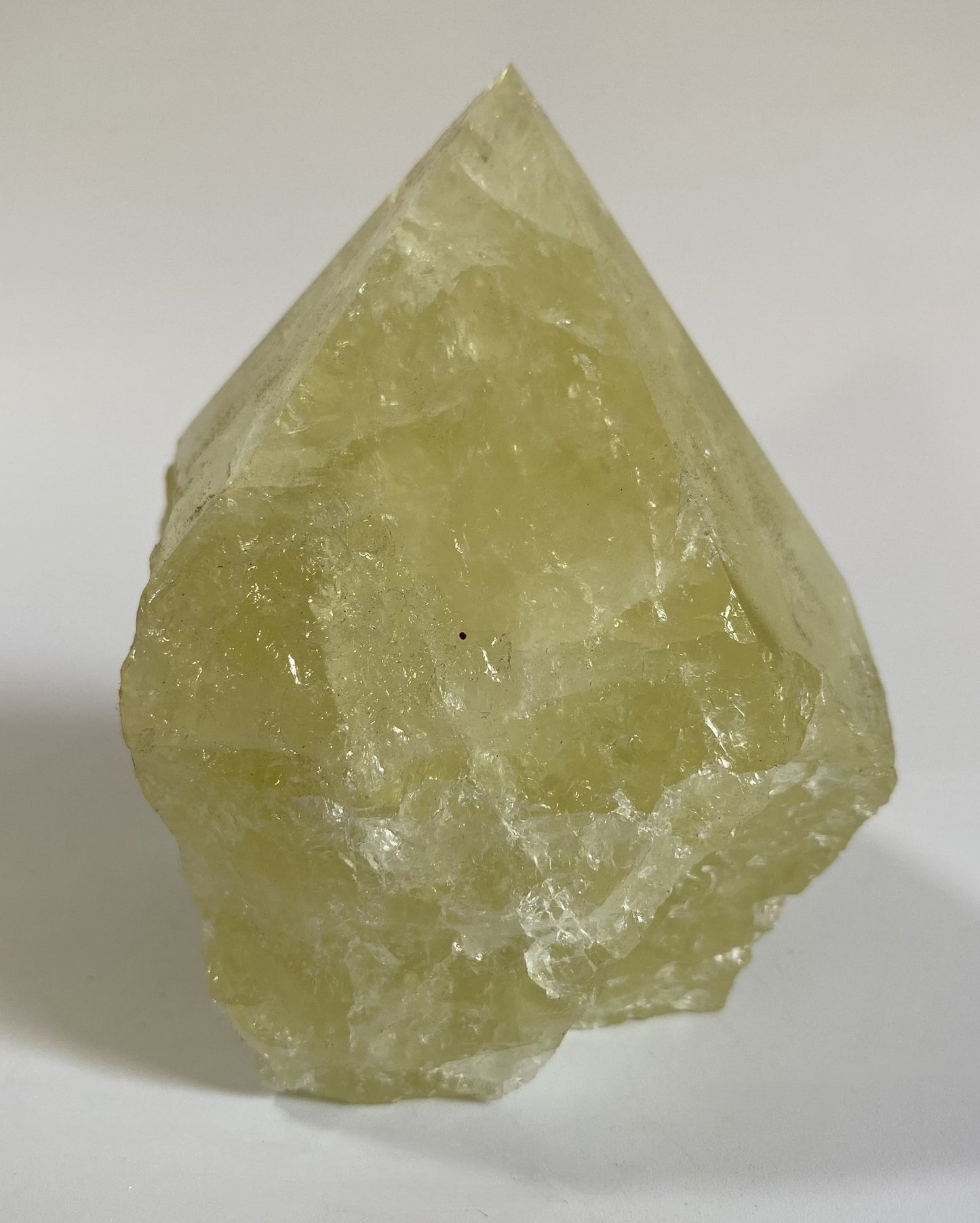 Varf polisat din cristal de citrin pe fundal alb sub lumina naturala