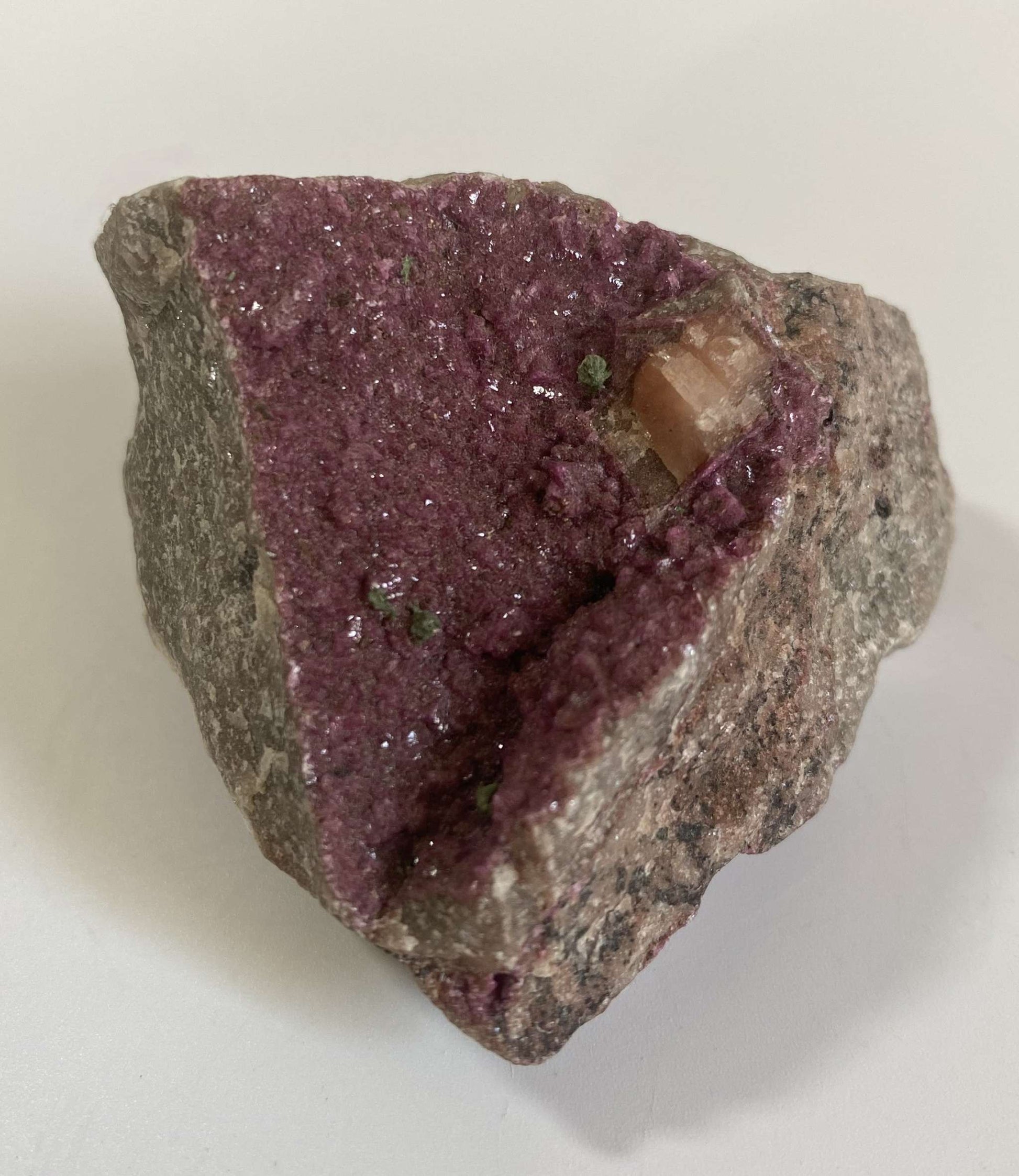 Cobaltocalcit semiprecious stone specimen with purple crystal surface on rock base