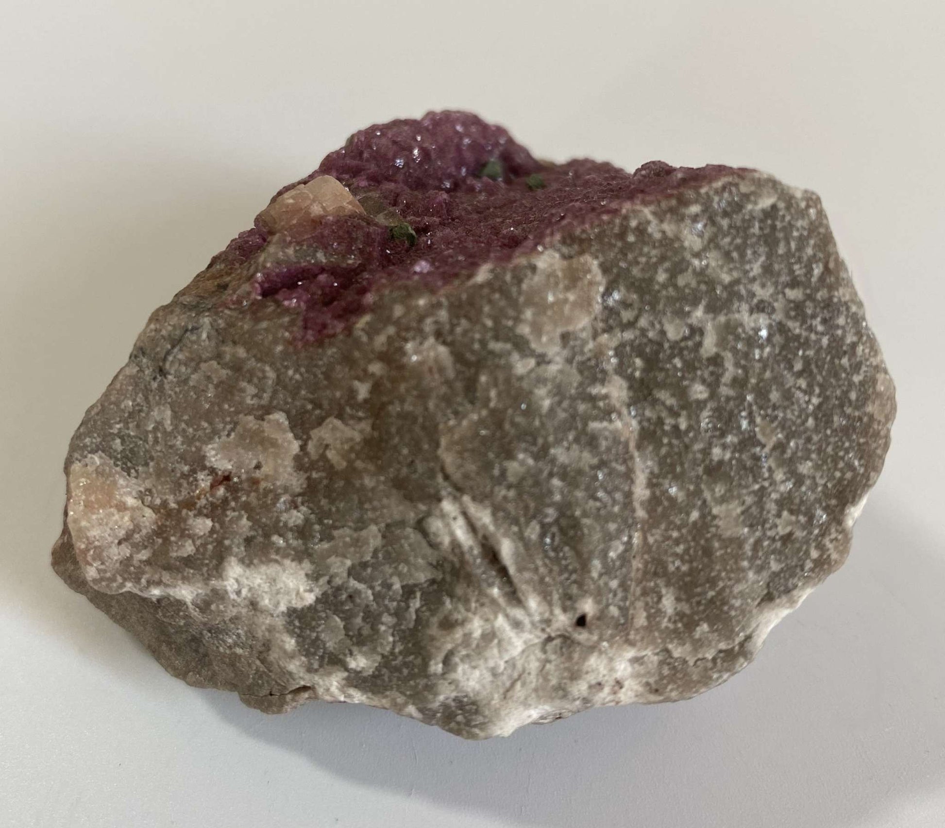 Cobaltocalcit specimen stone with purple crystal formations on gray rock background