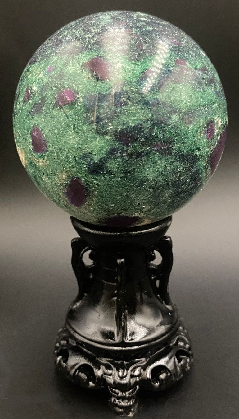 Sfera din piatra semipretioasa de corindon in fucsit pe suport decorativ cu fundal negru