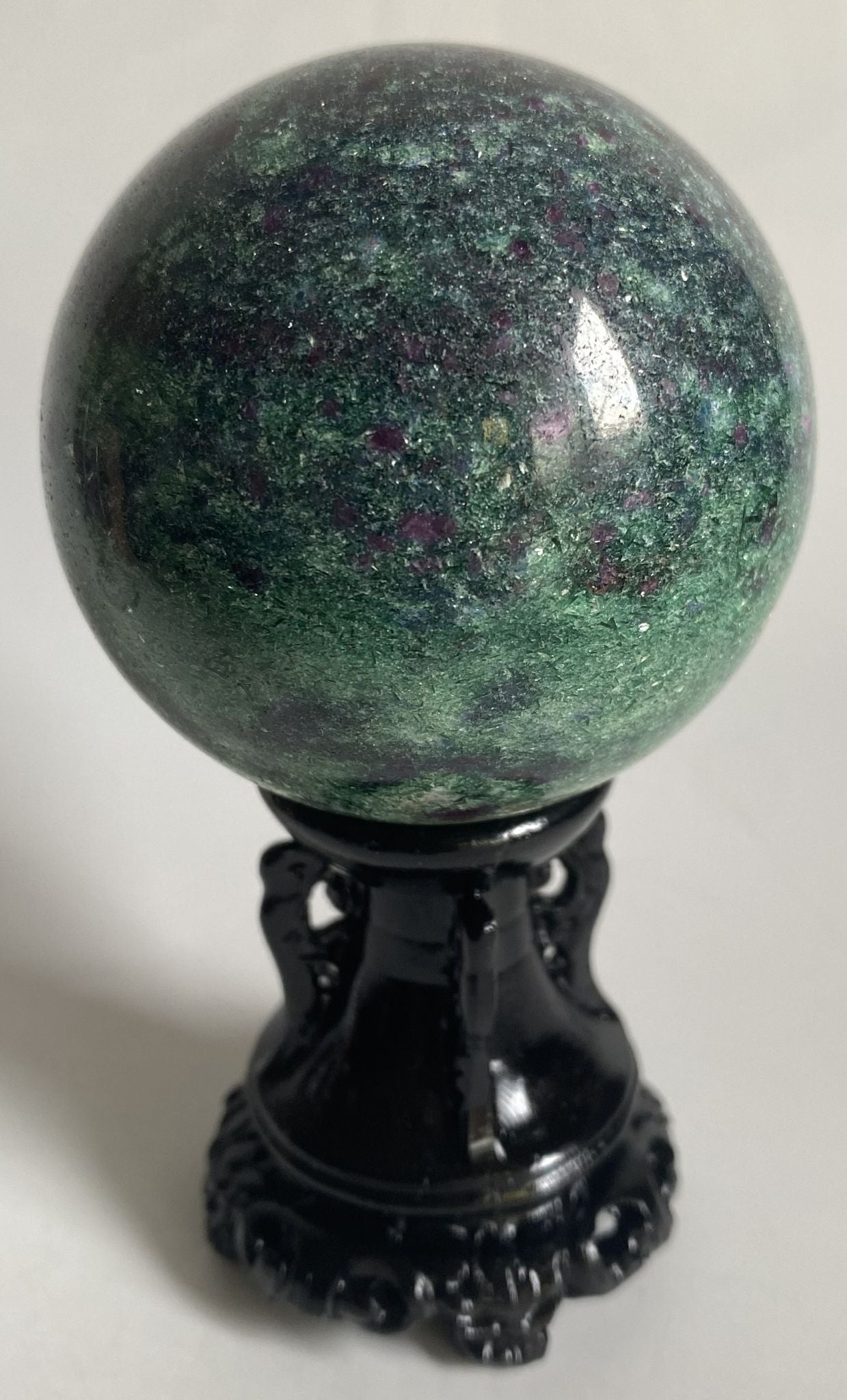 Sfera de 6.2cm din cristal de corindon in fucsit pe suport decorativ cu fundal alb