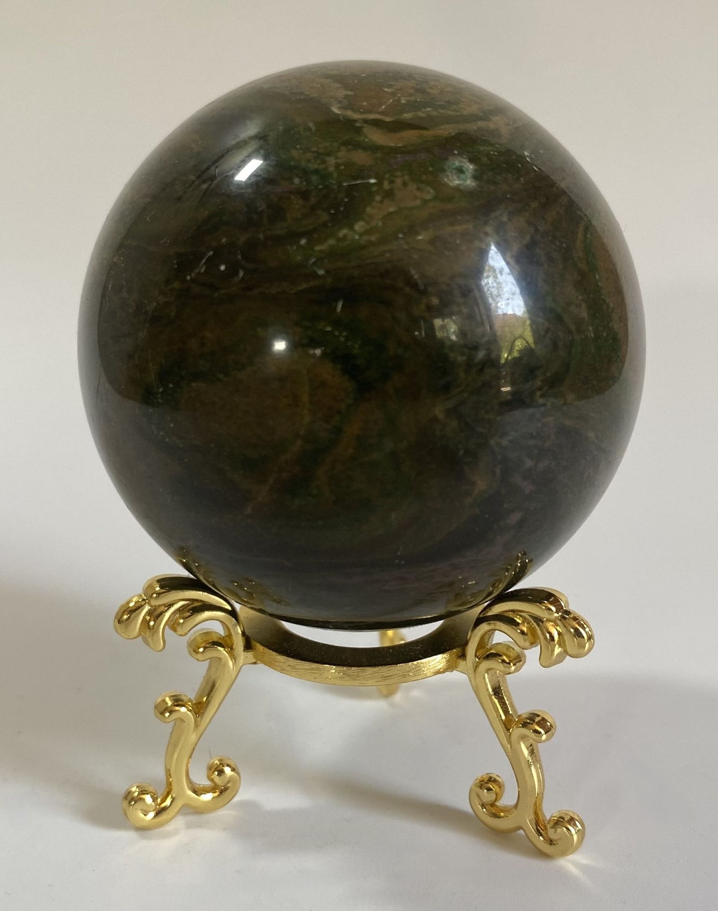 Sfera de 6cm din cristal de corindon rosu pe suport metalic cu fundal alb