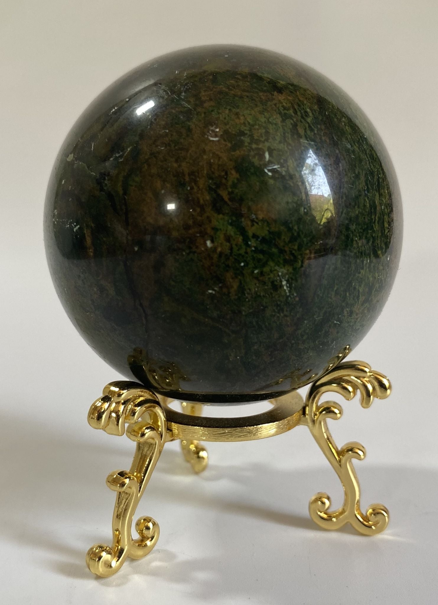 Sfera din cristal de corindon rosu pe suport metalic cu fundal alb