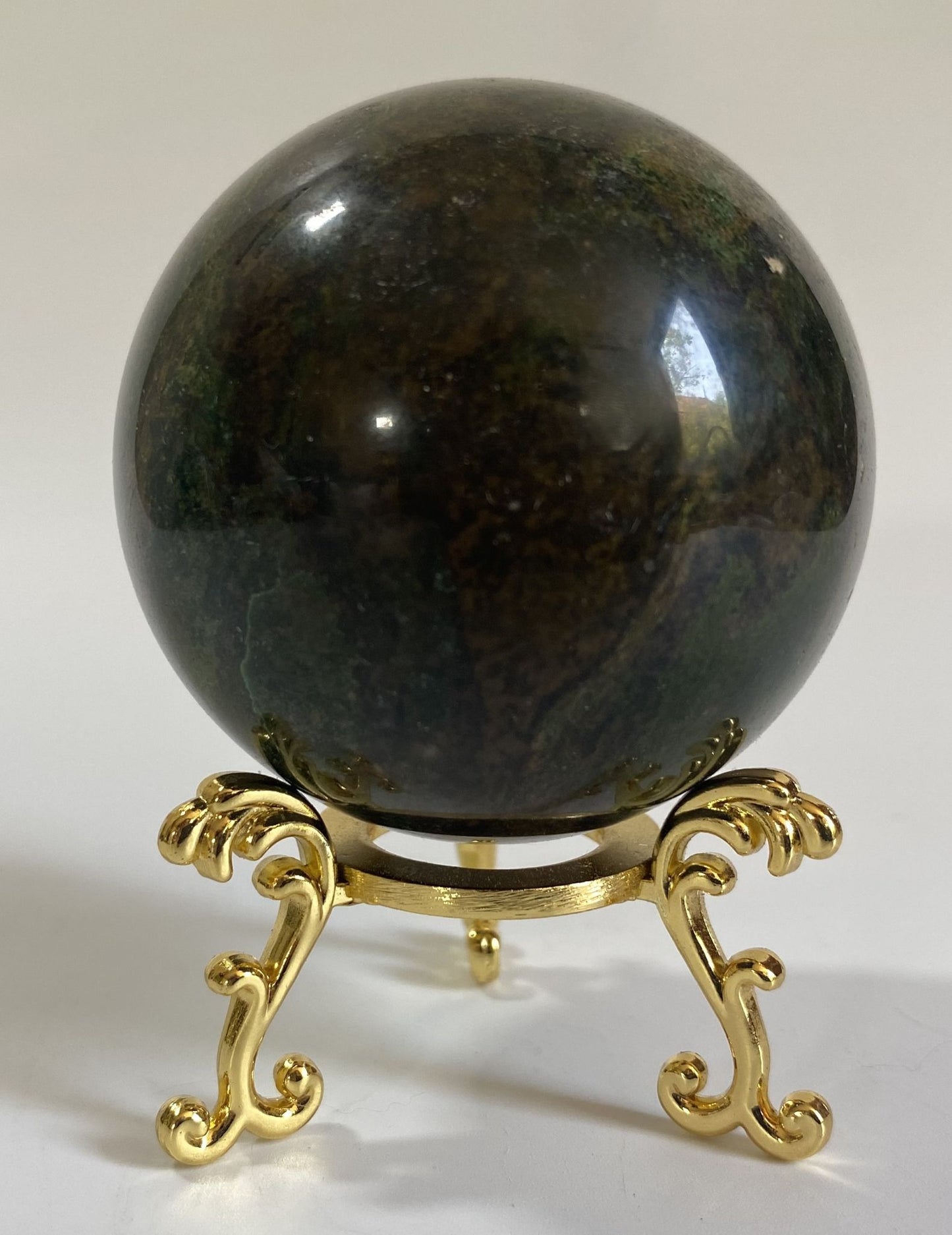 Sfera de 6cm din cristal de corindon rosu pe suport metalic cu fundal alb