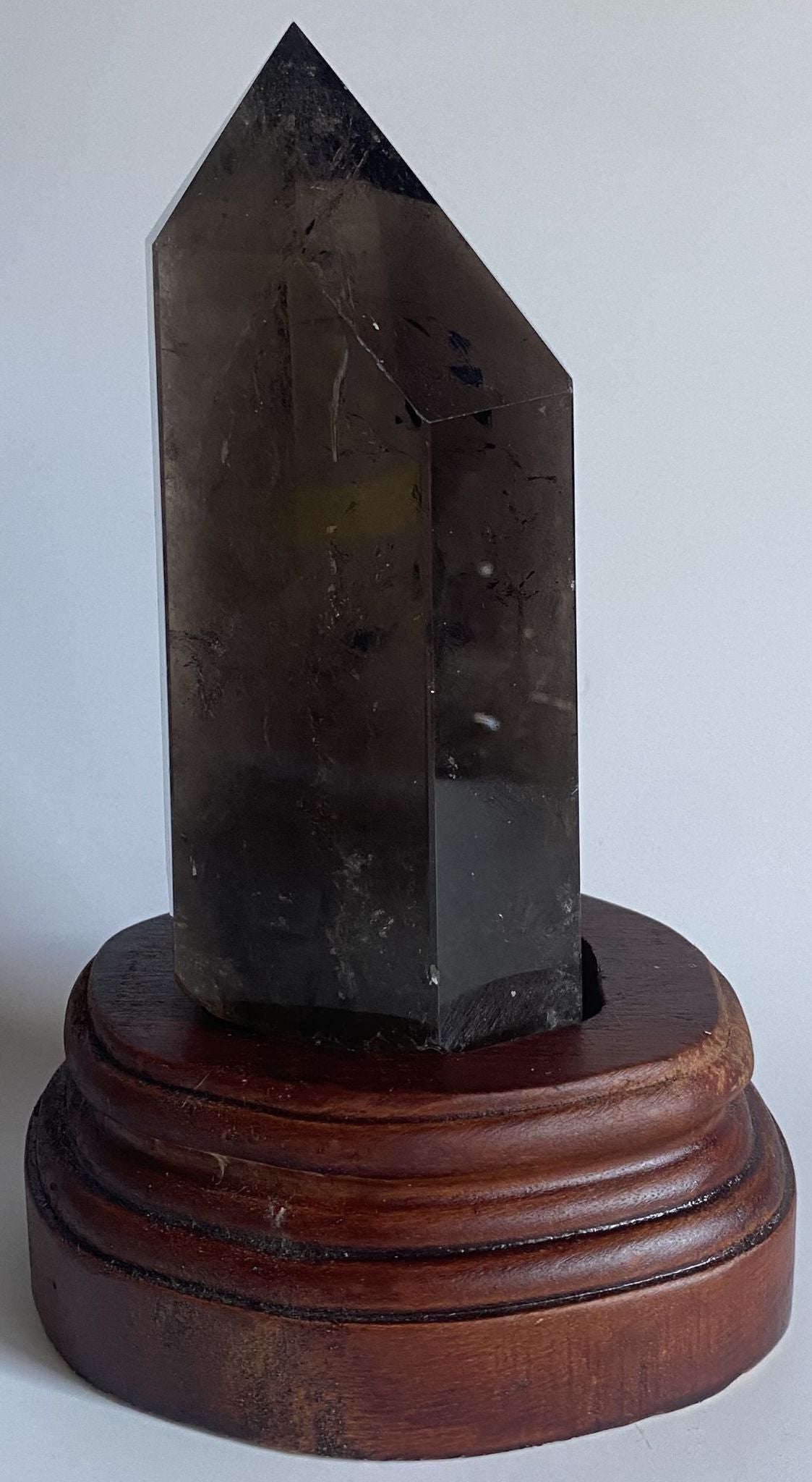 Obelisc din cristal de cuart fumuriu pe suport din lemn cu fundal alb