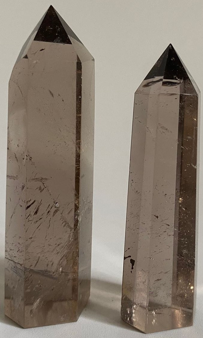 Doua obeliscuri din cristal vindecator de cuart fumuriu pe fundal alb