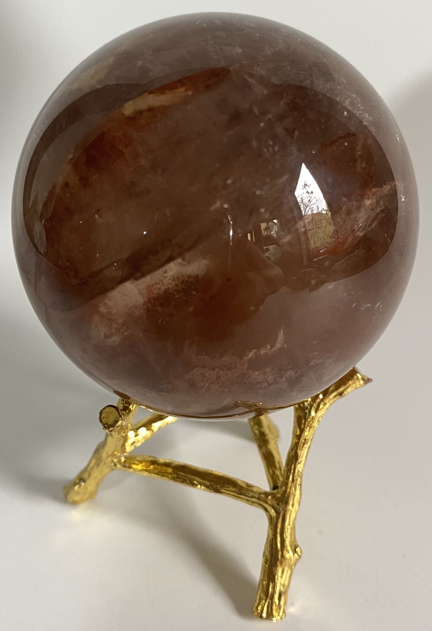Sfera din cristal de cuart hematoid rosu pe suport metalic cu fundal alb