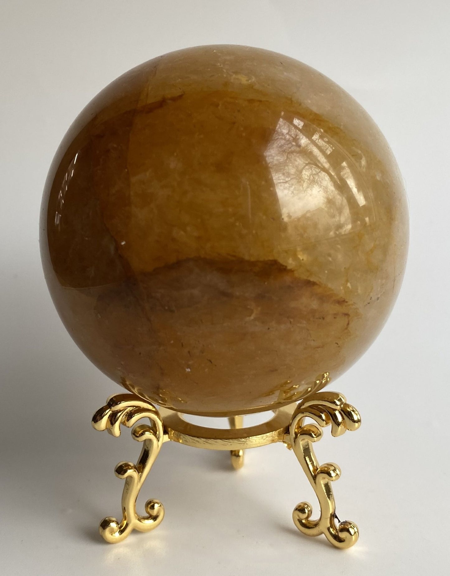 Sfera din cristal de cuart hematoid galben pe suport metalic cu fundal alb