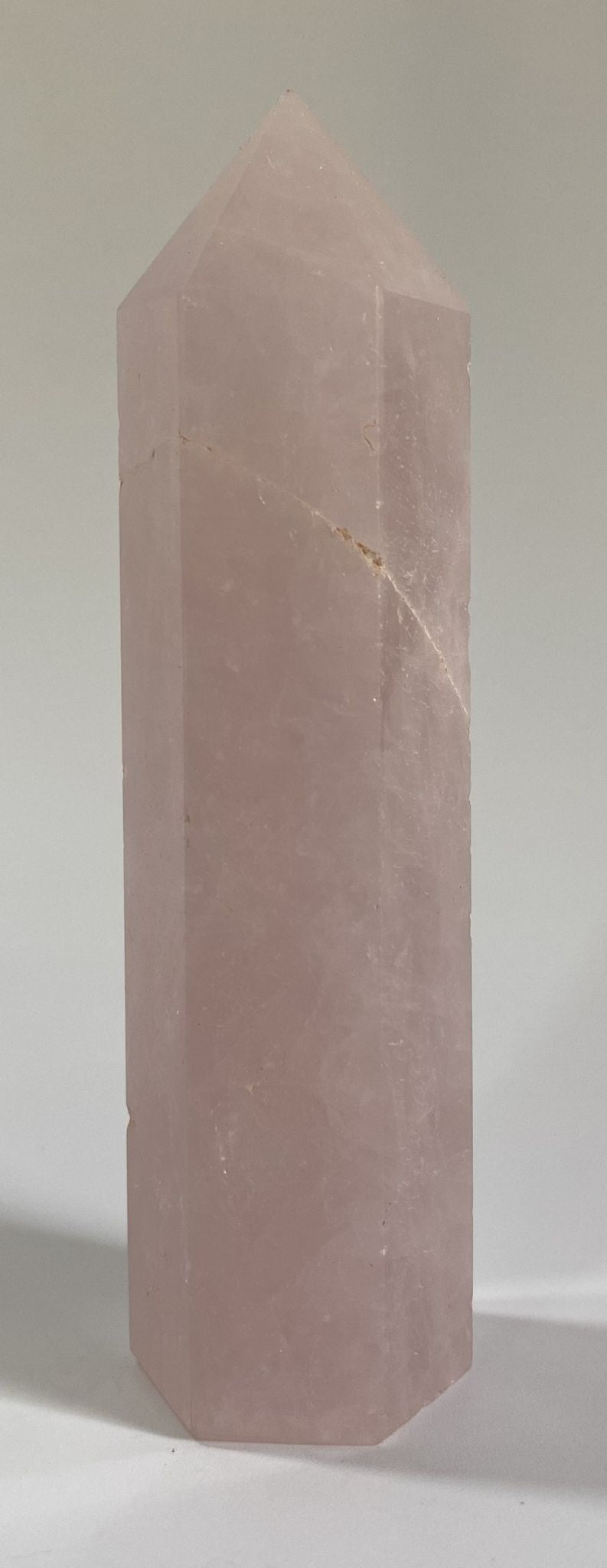 Obelisc din cristal de cuart roz pe fundal alb