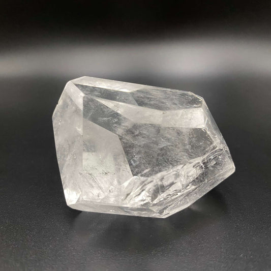 Cuart transparent cristalin poligonal de 5.9 cm pe fundal negru