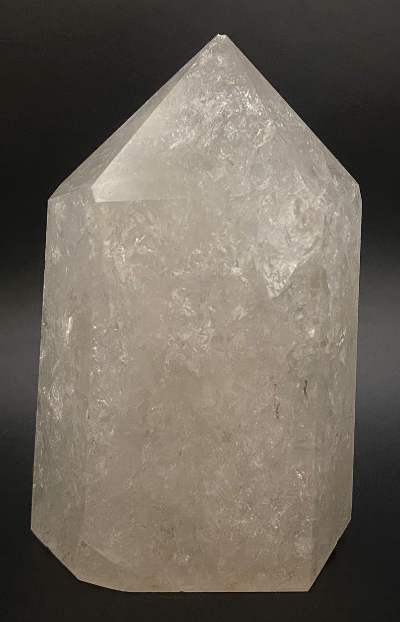 Obelisc din cristal vindecator de cuart transparent pe fundal negru