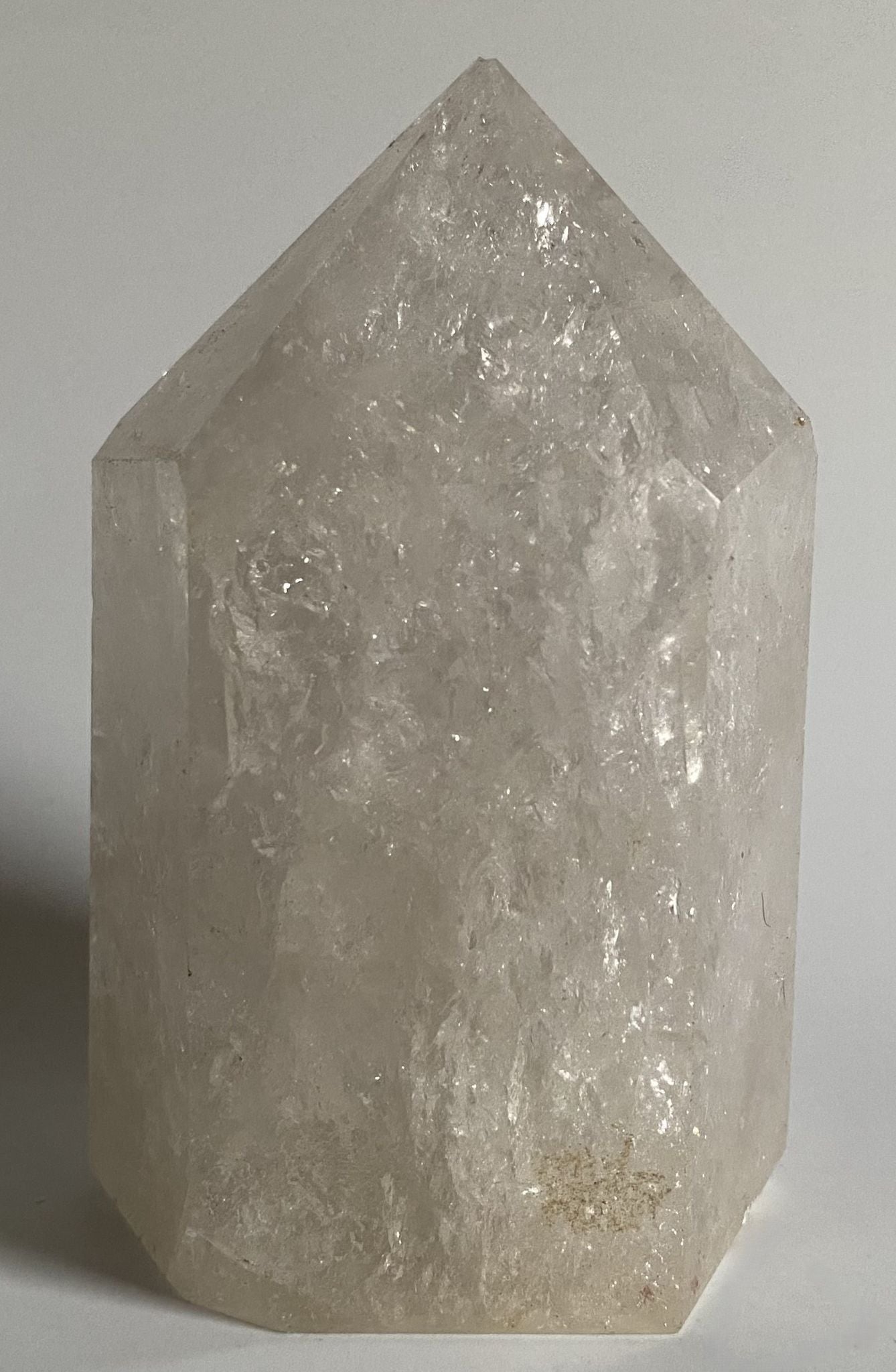 Obelisc din cristal vindecator de cuart transparent pe fundal alb