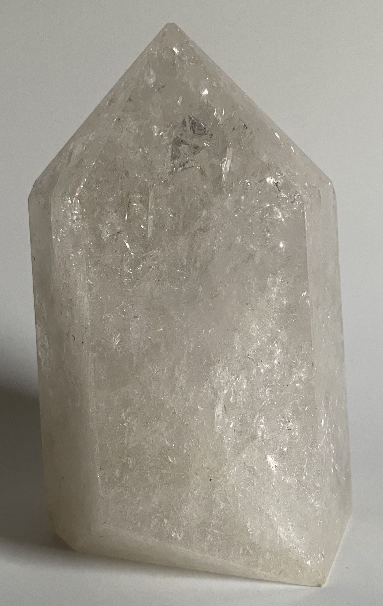 Obelisc din cristal de stanca de cuart transparent pe fundal alb