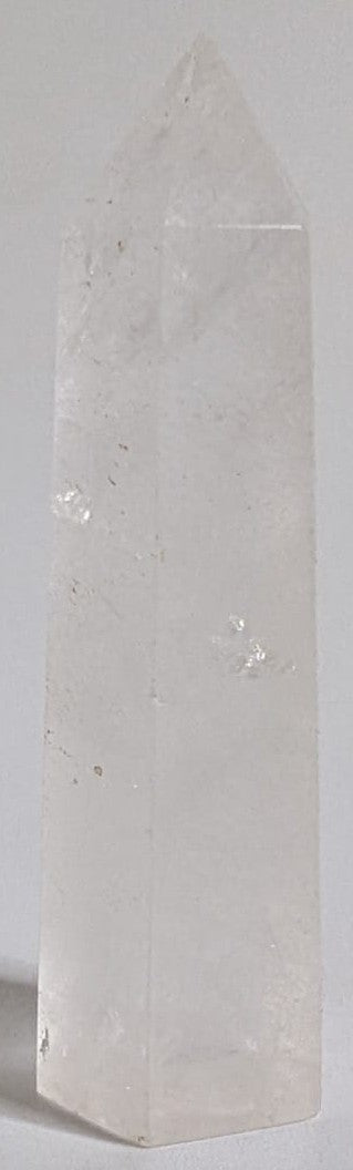 Obelisc din cristal de cuart transparent pe fundal alb
