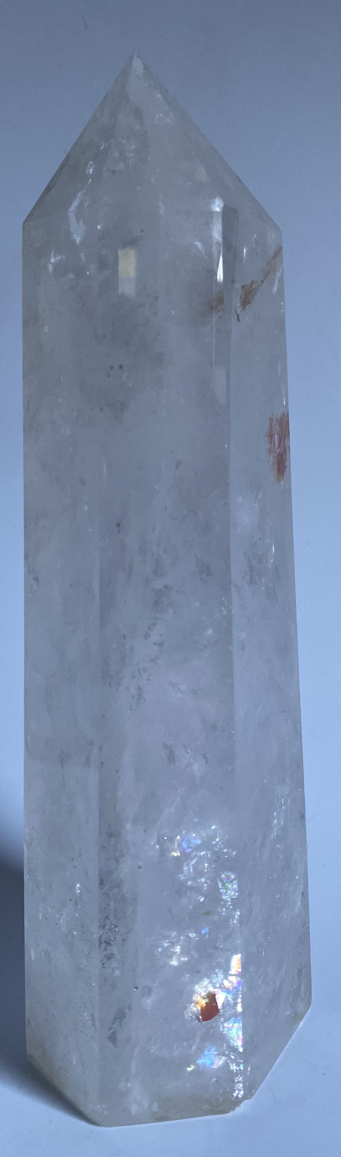 Obelisc de 22 cm din cristal de stanca pe fundal alb sub lumina naturala