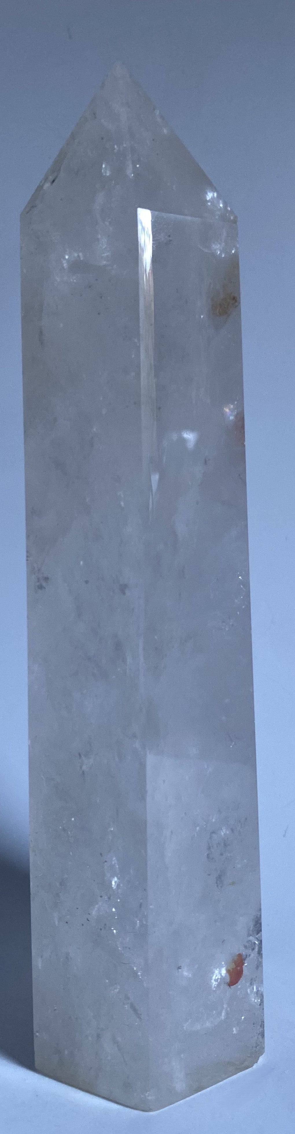 Obelisc de 22 cm din cristal de stanca pe fundal alb sub lumina naturala
