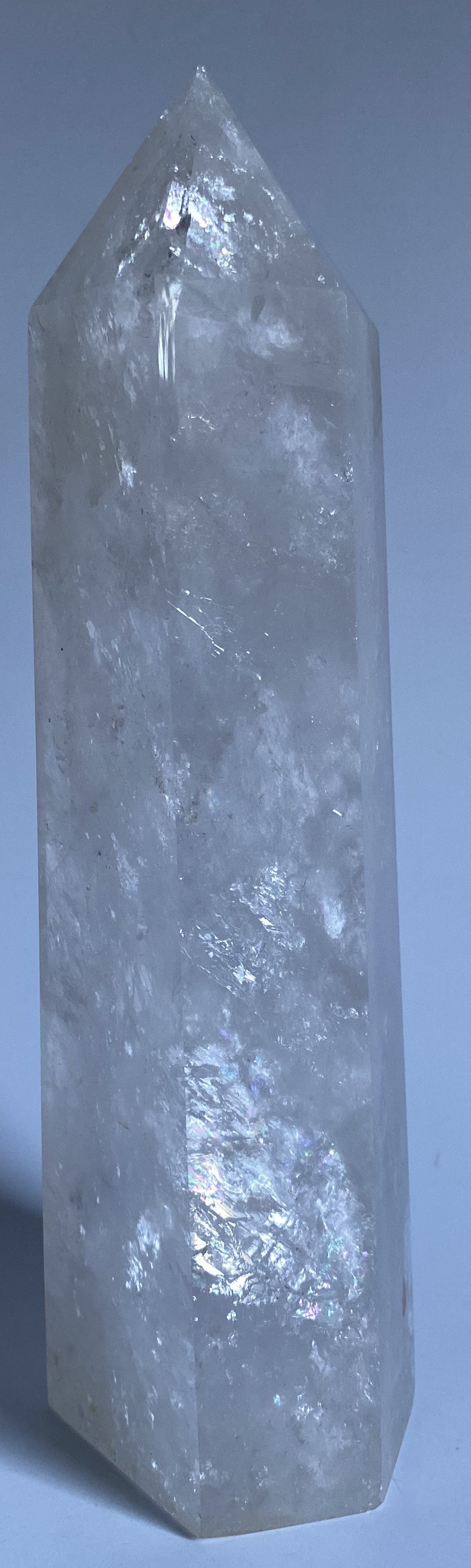 Obelisc de 22 cm din cristal de stanca pe fundal alb sub lumina naturala