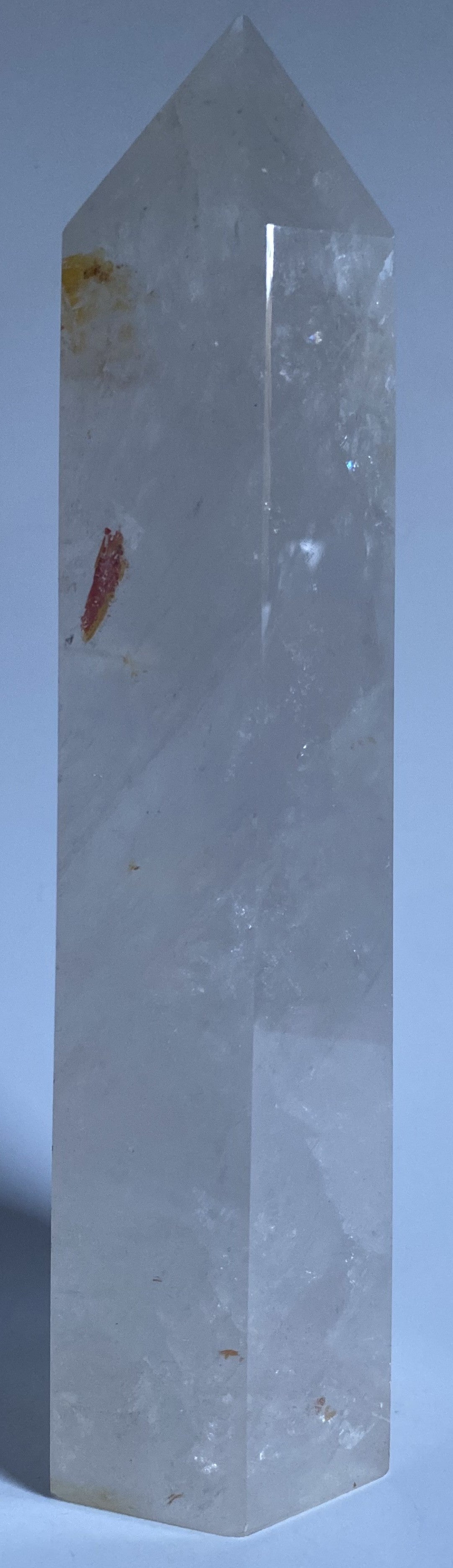 Obelisc de 22 cm din cristal de stanca pe fundal alb sub lumina naturala