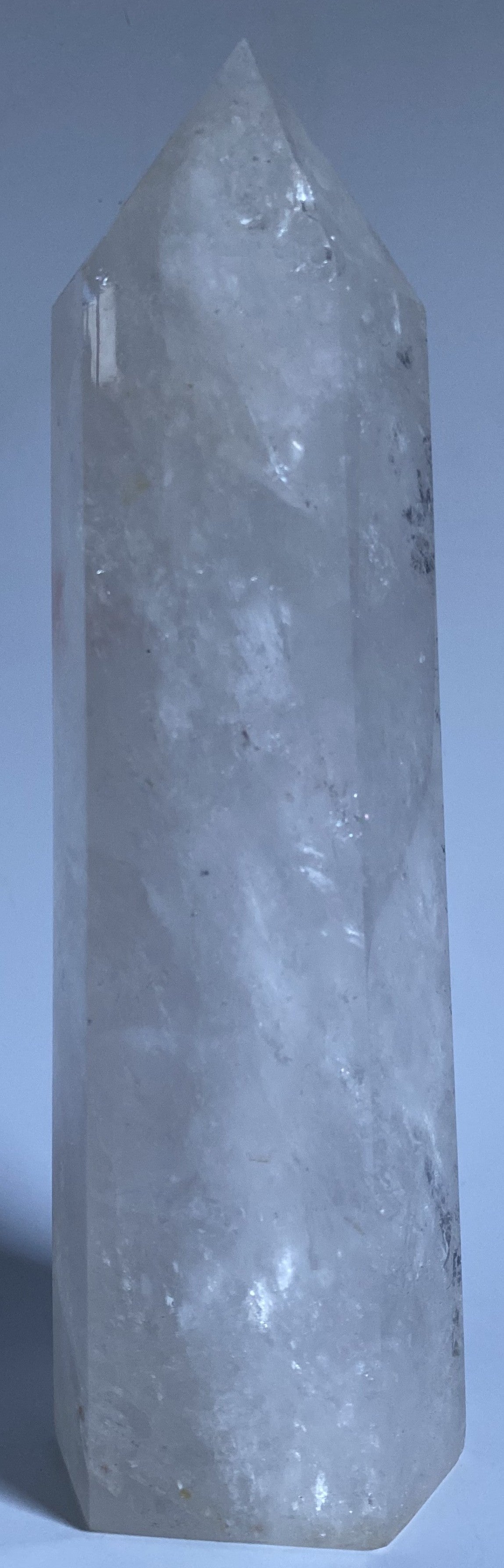 Obelisc de 22 cm din cristal de stanca pe fundal alb sub lumina naturala