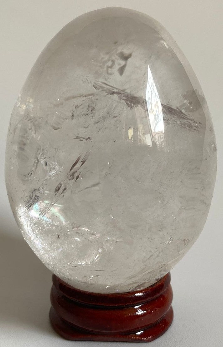 Ou din cristal de cuart transparent pe suport din lemn cu fundal alb