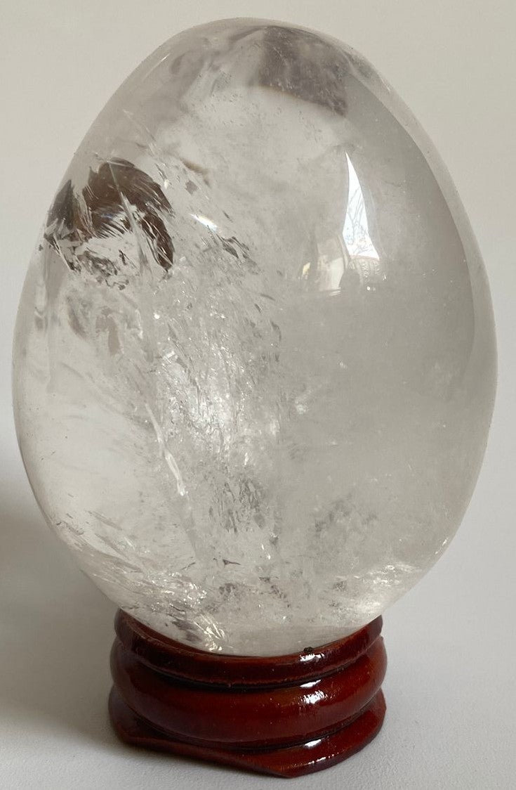 Ou de 6.4cm din piatra semipretioasa de cuart transparent pe suport din lemn cu fundal alb