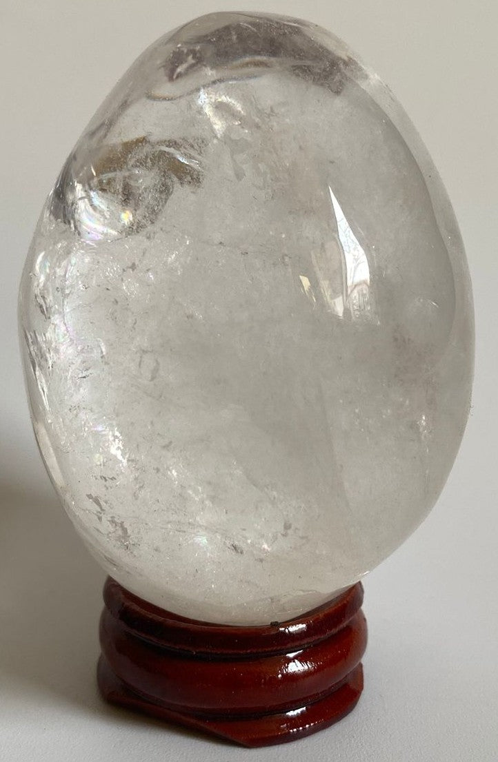 Ou de 6.4cm din cristal de cuart transparent pe suport din lemn cu fundal alb