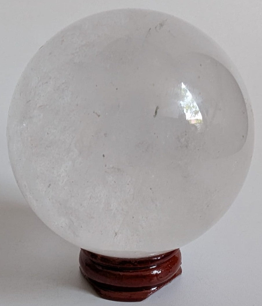 Sfera decorativa de 6.2cm din piatra semipretioasa de cuart transparent pe suport din lemn cu fundal alb