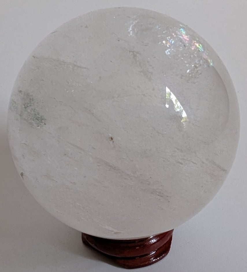 Sfera unicat de 6.2cm din piatra semipretioasa de cuart transparent pe suport din lemn cu fundal alb