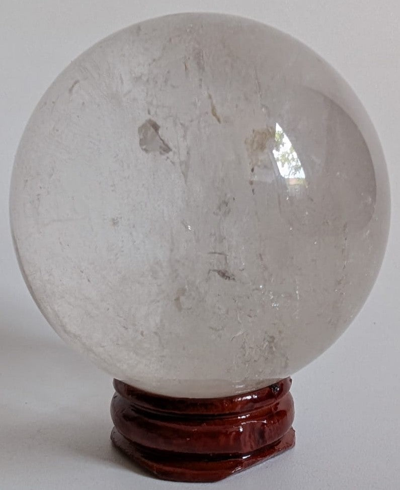 Sfera din piatra semipretioasa de cristal de stanca pe suport din lemn cu fundal alb