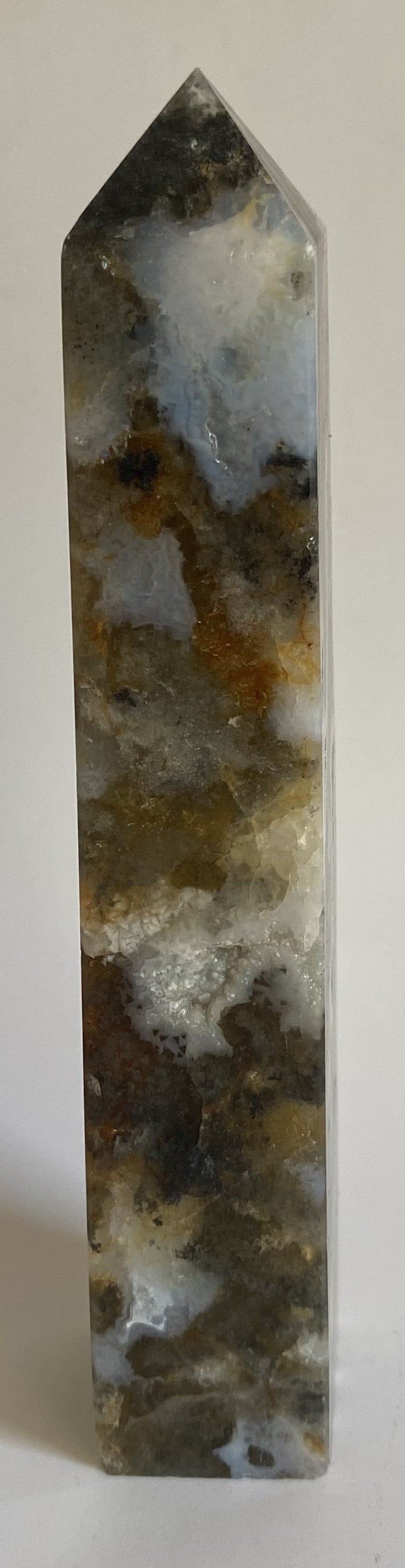 Obelisc din simbiot de fluorit cu agat pe fundal alb sub lumina naturala