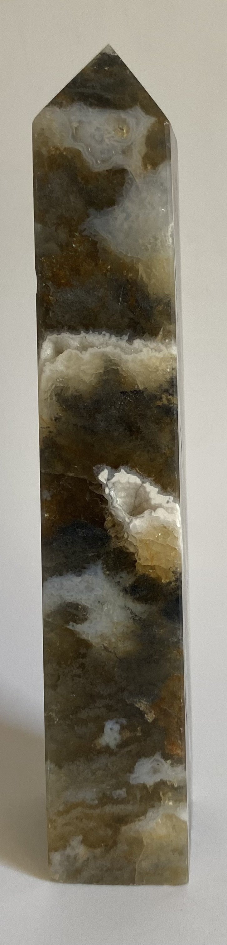 Obelisc din simbiot de fluorit cu agat pe fundal alb sub lumina naturala