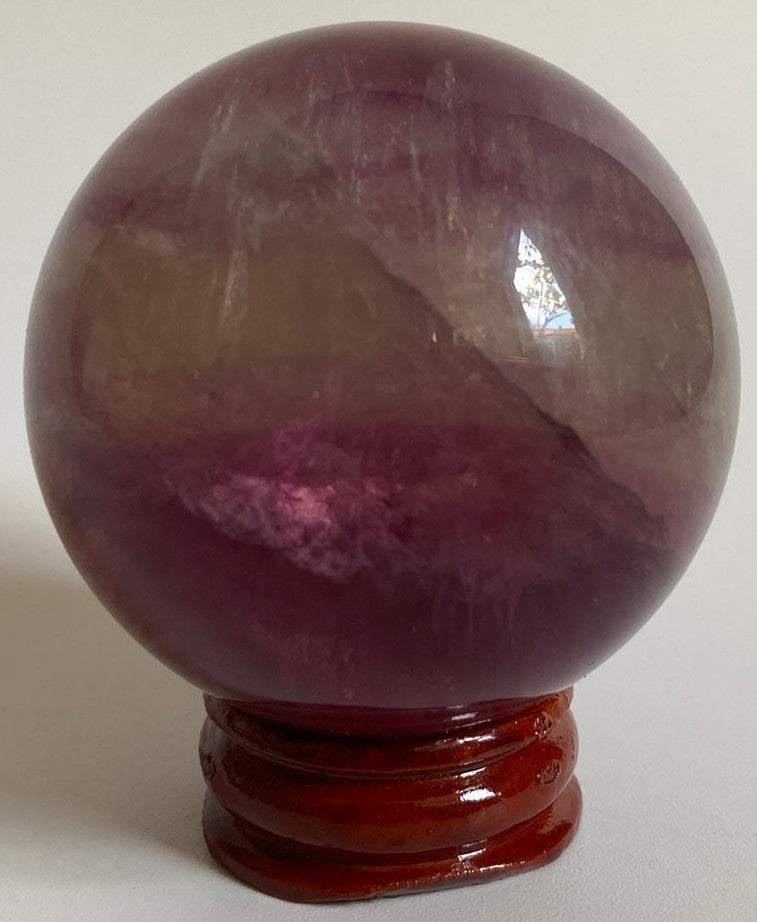 Sfera de 5.2cm din piatra semipretioasa de fluorit candy pe suport din lemn cu fundal alb