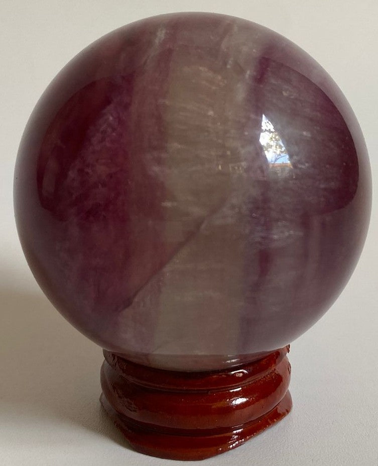Sfera unicat de 5.2cm din piatra semipretioasa de fluorit candy pe suport din lemn cu fundal alb