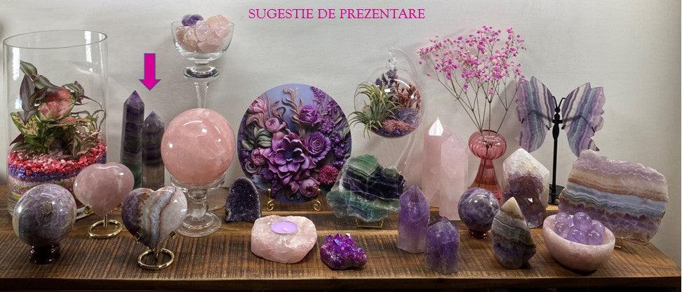 Two Fluorit Rainbow obelisks among various semiprecious stones and decorative crystals displayed on wooden surface