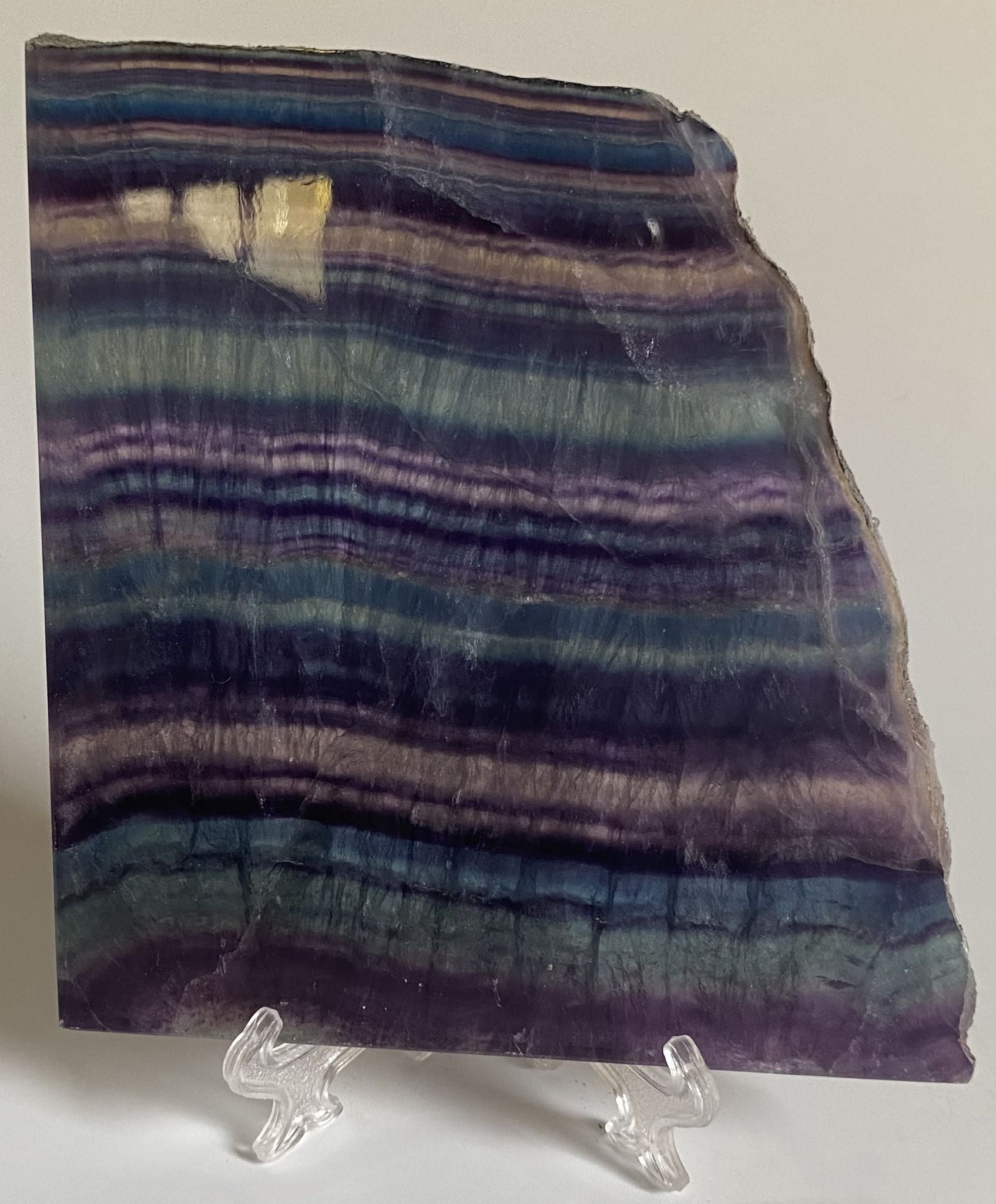 Felie din cristal de fluorit rainbow pe suport din plastic cu fundal alb