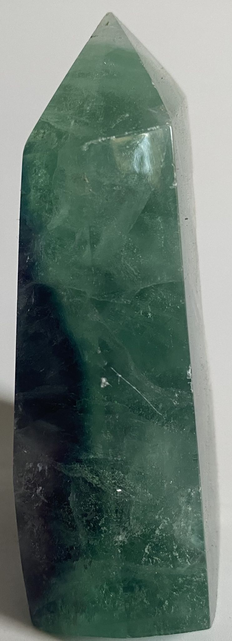 Obelisc brut din cristal de fluorit rainbow pe fundal alb