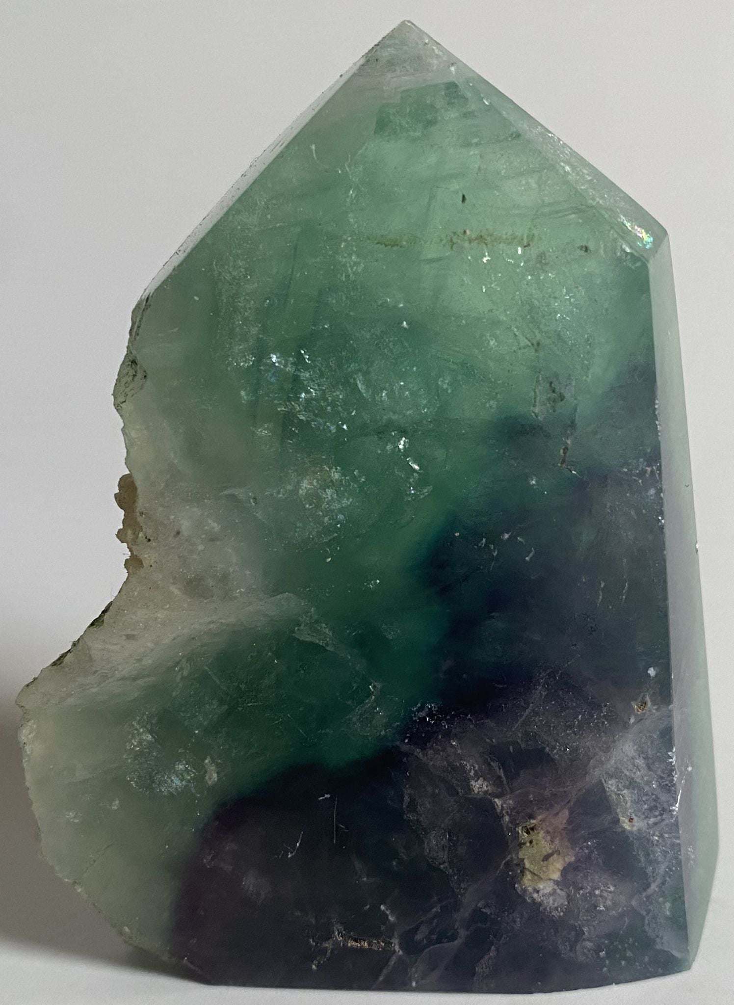 Obelisc brut de 9.3cm din piatra semipretioasa de fluorit rainbow pe fundal alb