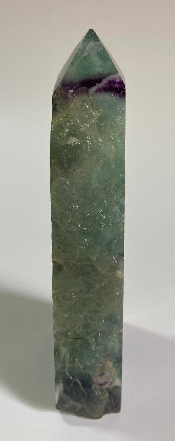 Obelisc brut din cristal de fluorit rainbow pe fundal alb