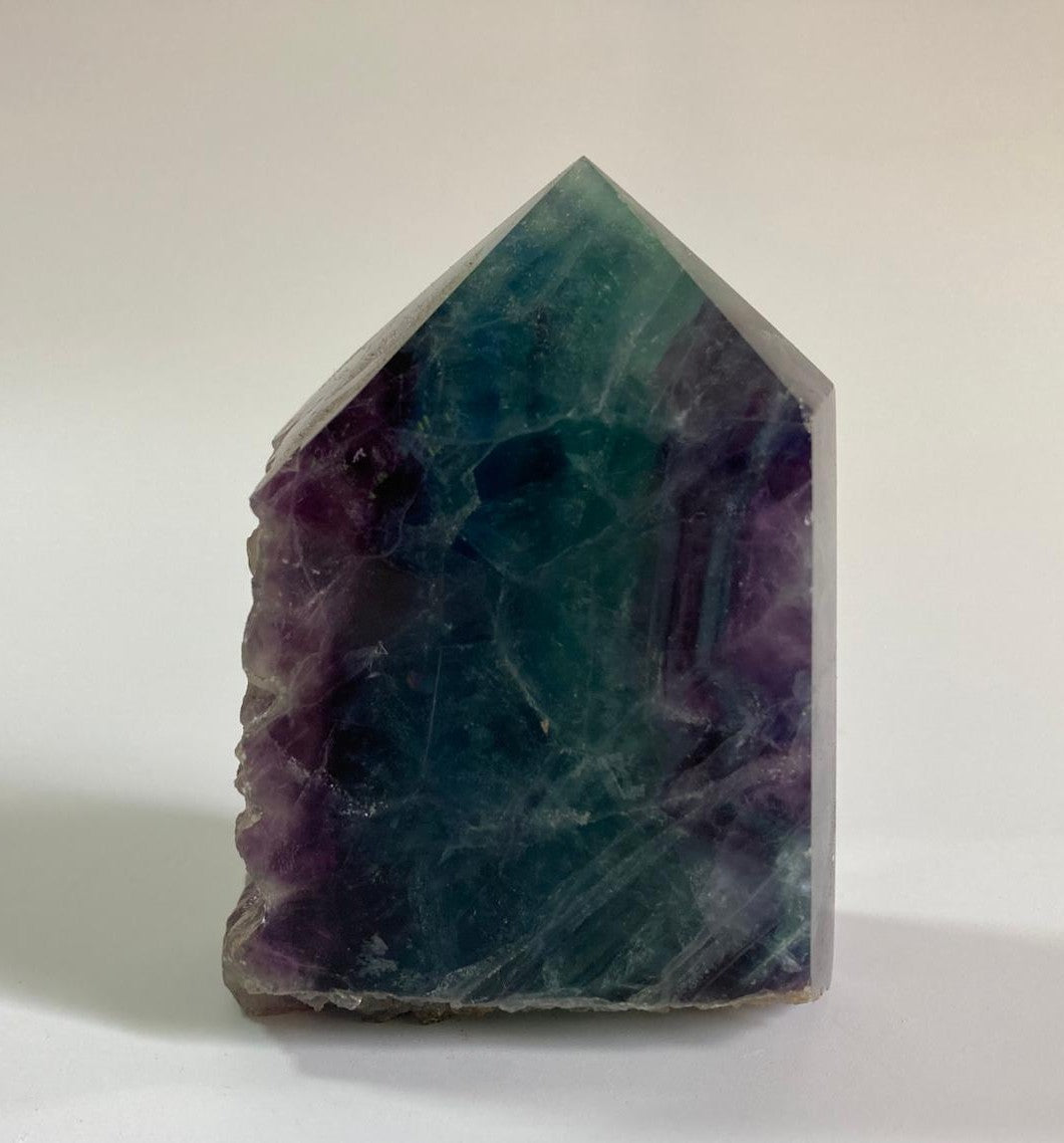 Obelisc brut din cristal de fluorit rainbow pe fundal alb
