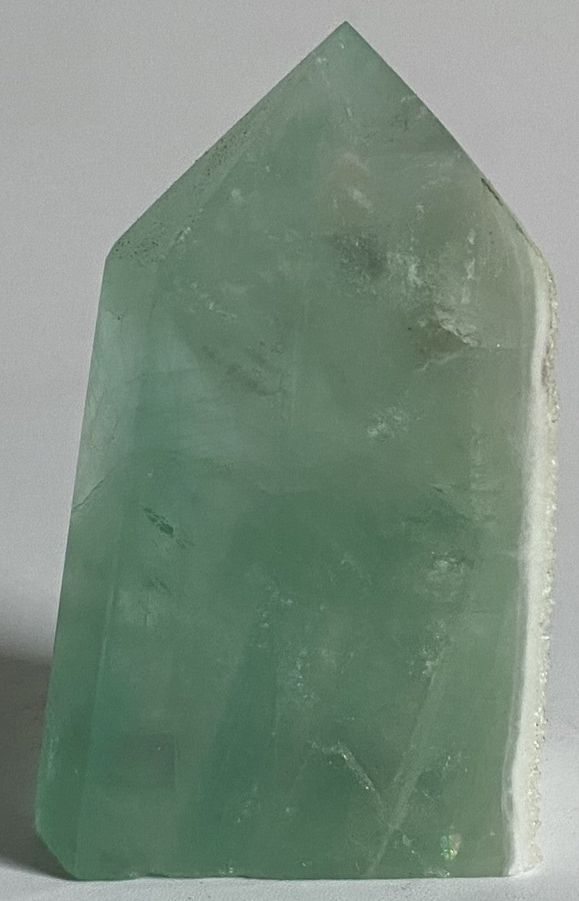 Obelisc brut din piatra semipretioasa de fluorit verde pe fundal alb