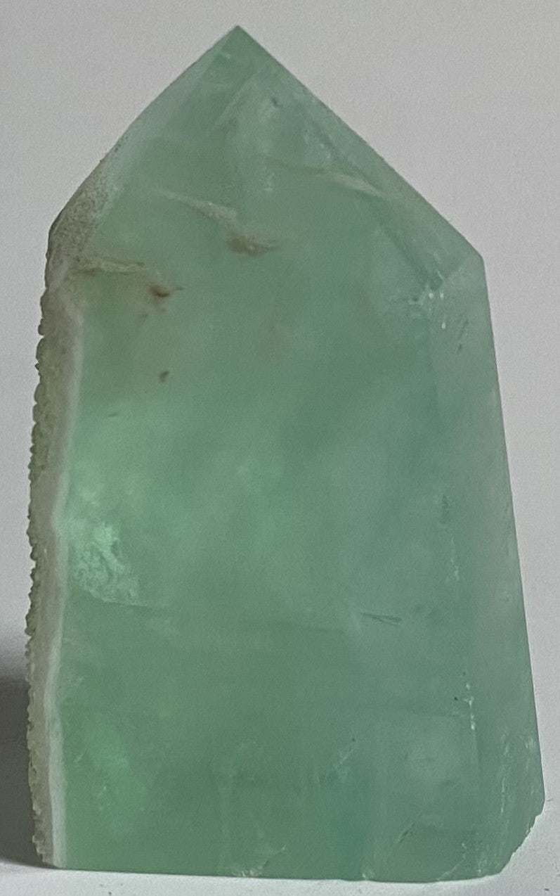 Obelisc brut de 5.8cm din cristal de fluorit verde pe fundal alb