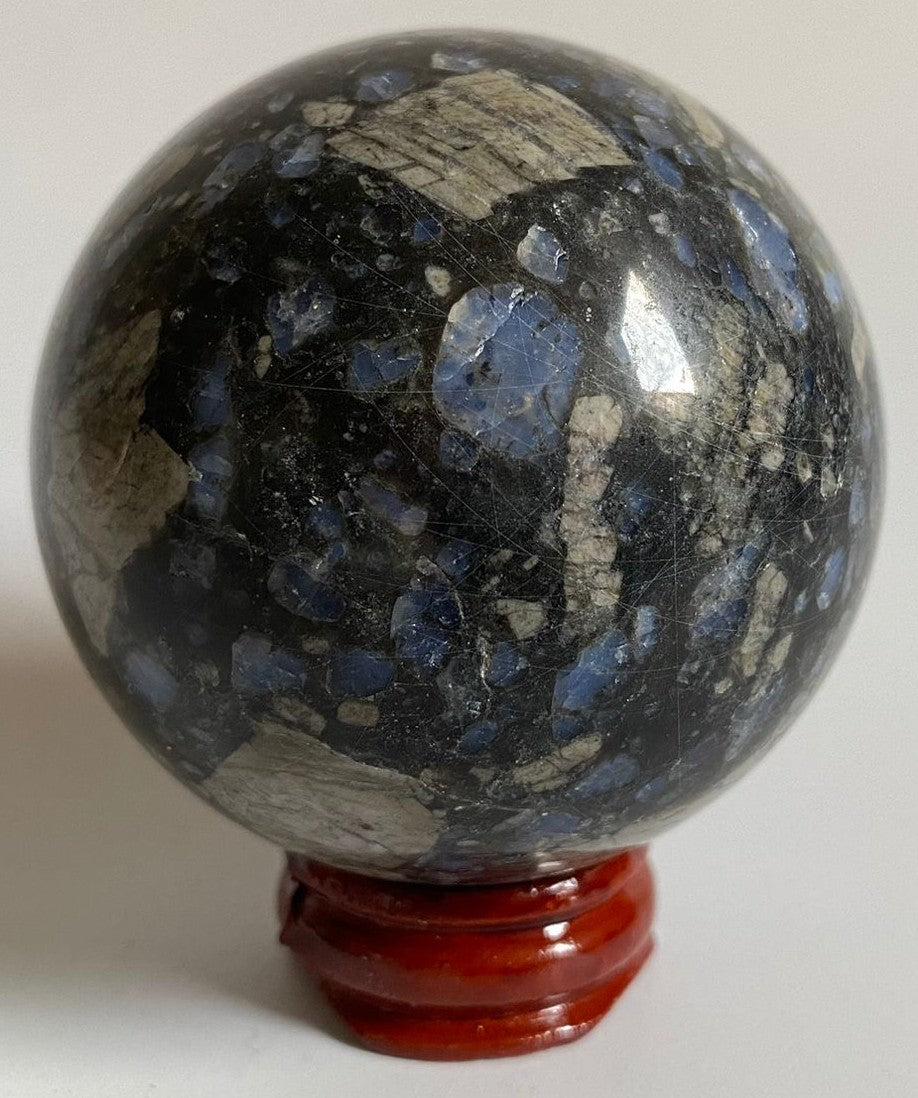 Sfera de 6.1cm din cristal de glaucofan pe suport din lemn cu fundal alb