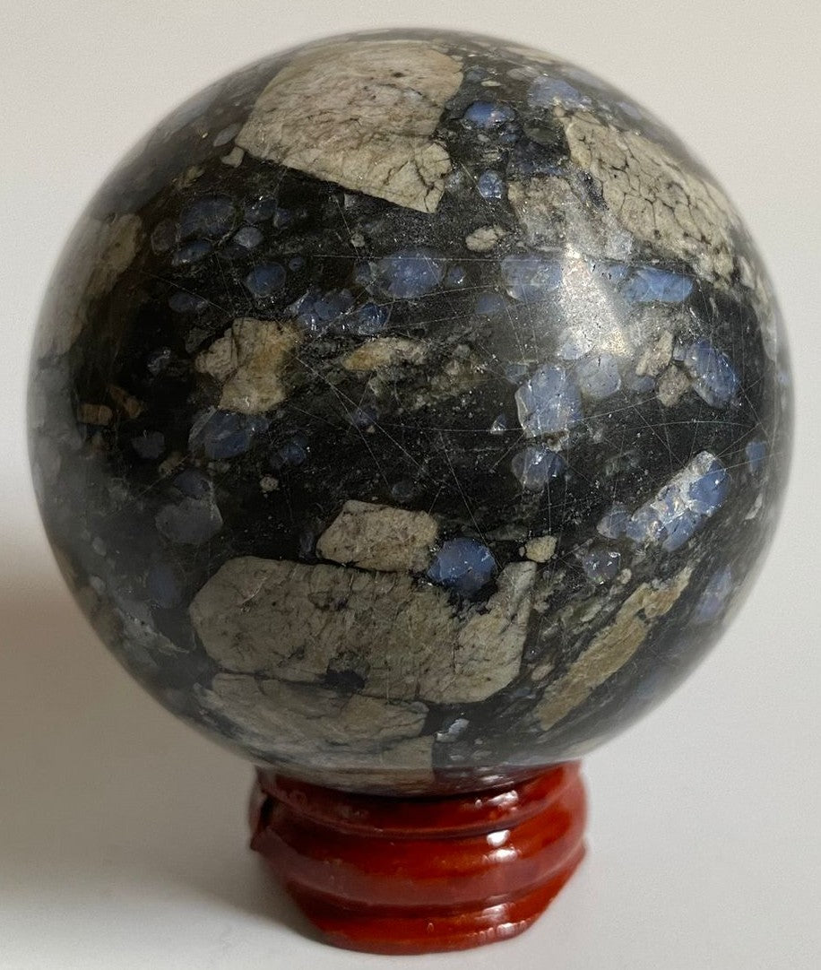 Sfera de 6.1cm din piatra semipretioasa de que sera pe suport din lemn cu fundal alb
