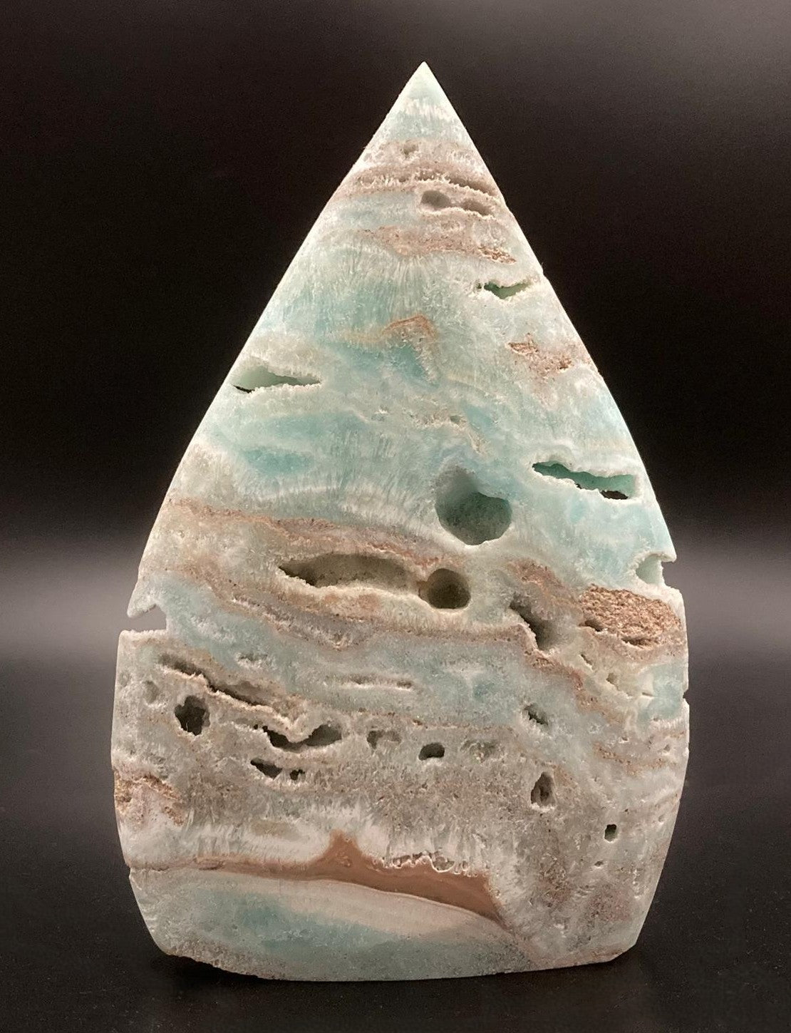 Sculptura din hemimorfit pe fond negru sub lumina artificiala