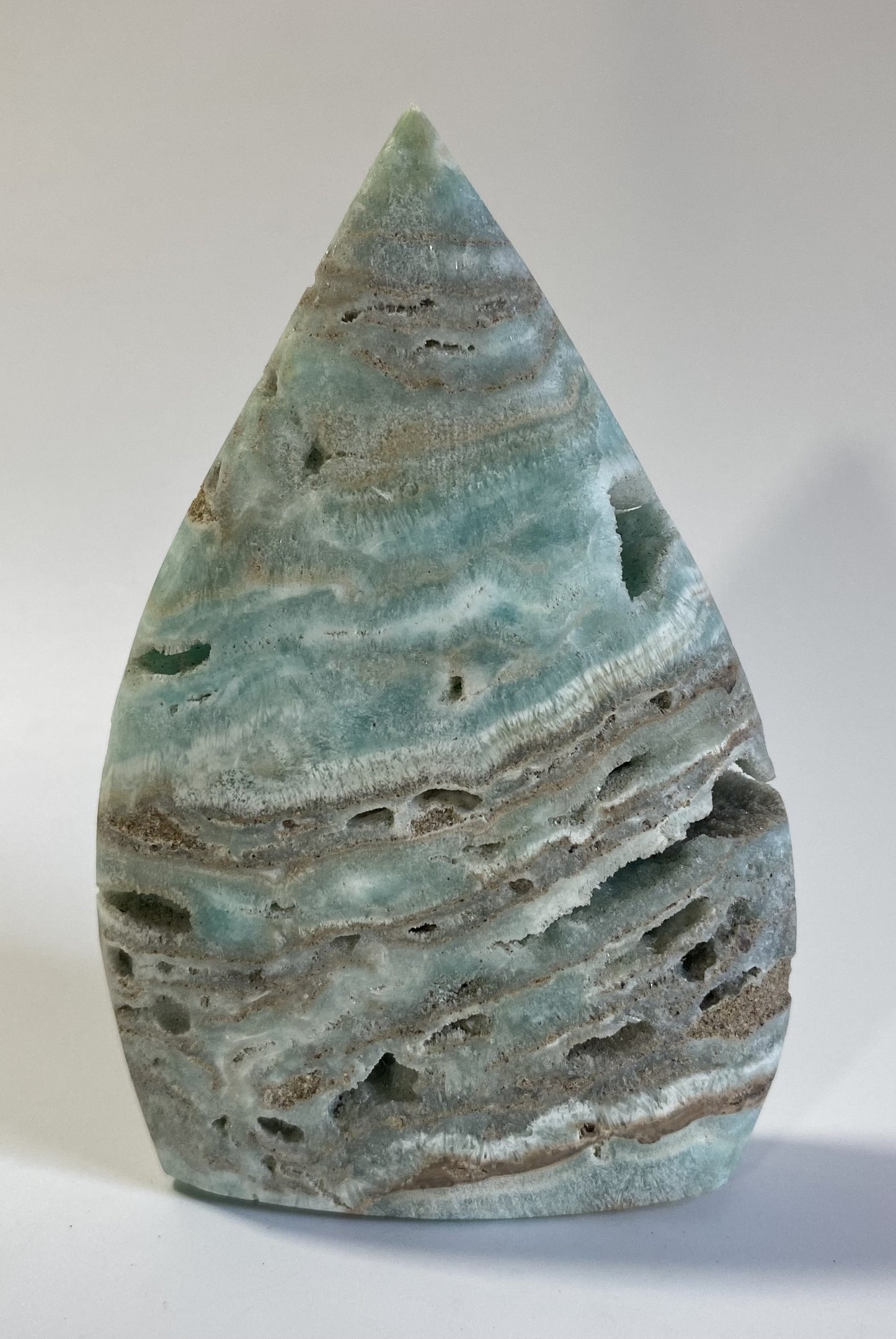 Sculptura din hemimorfit pe fond alb sub lumina naturala
