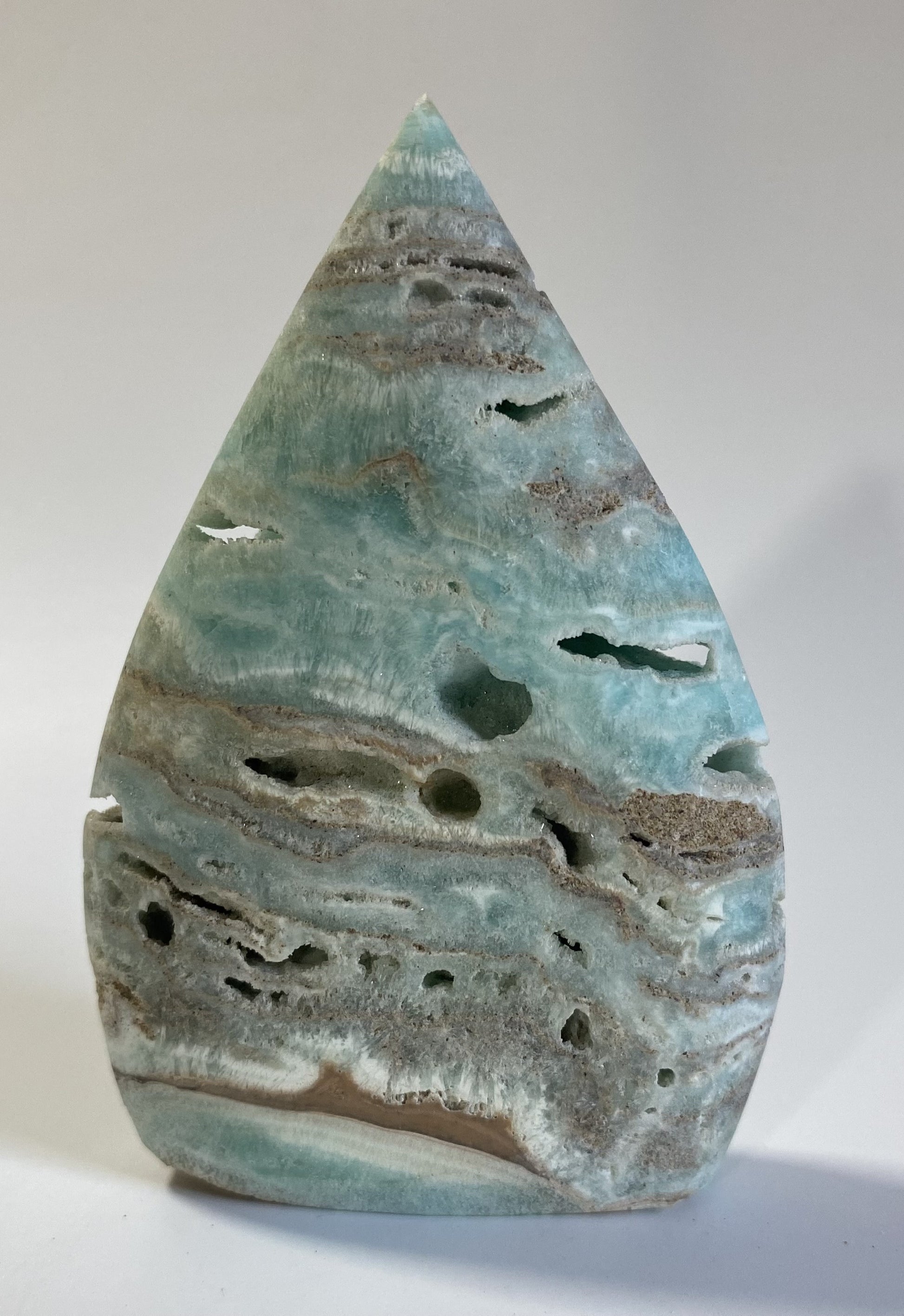 Sculptura din hemimorfit pe fond alb sub lumina naturala
