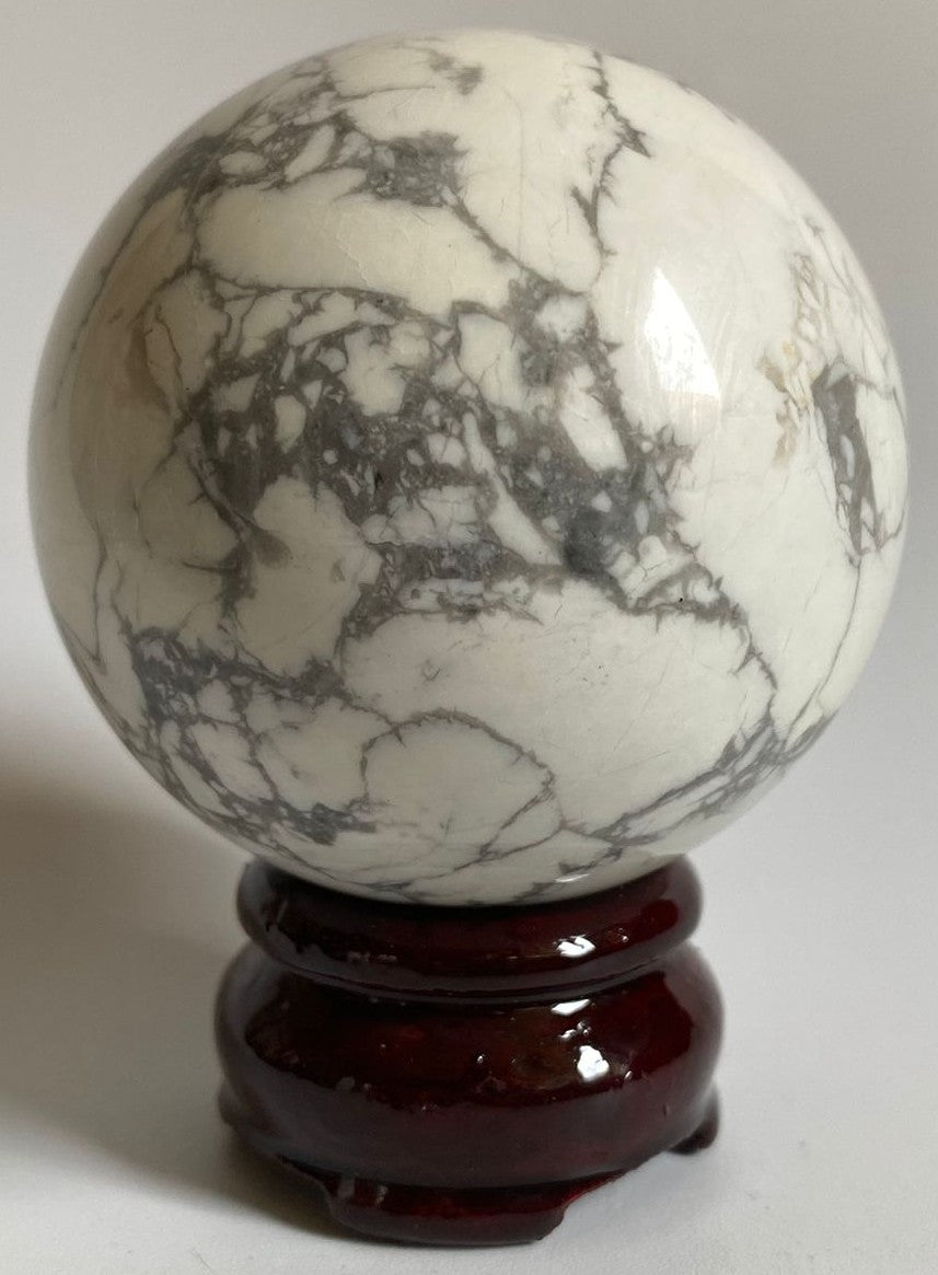 Sfera de 6.5cm din cristal de howlit pe suport din lemn cu fundal alb